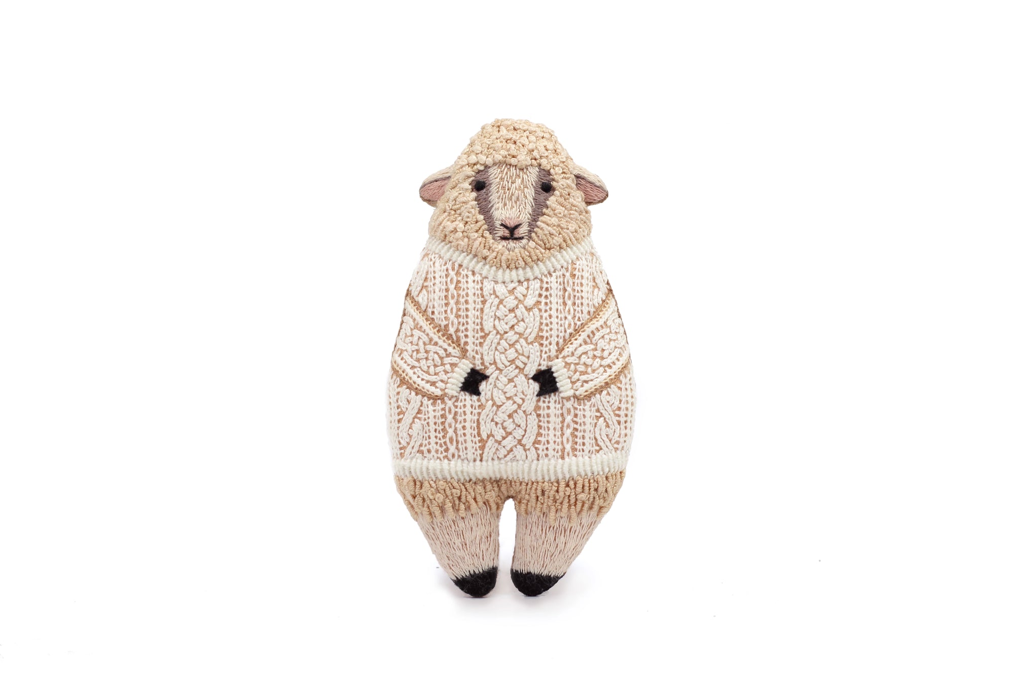The Sheep Embroidery Kit by Faire is displayed against a plain white background, featuring a plush sheep upright in a detailed cream-colored knitted sweater with charming sheep embroidery.