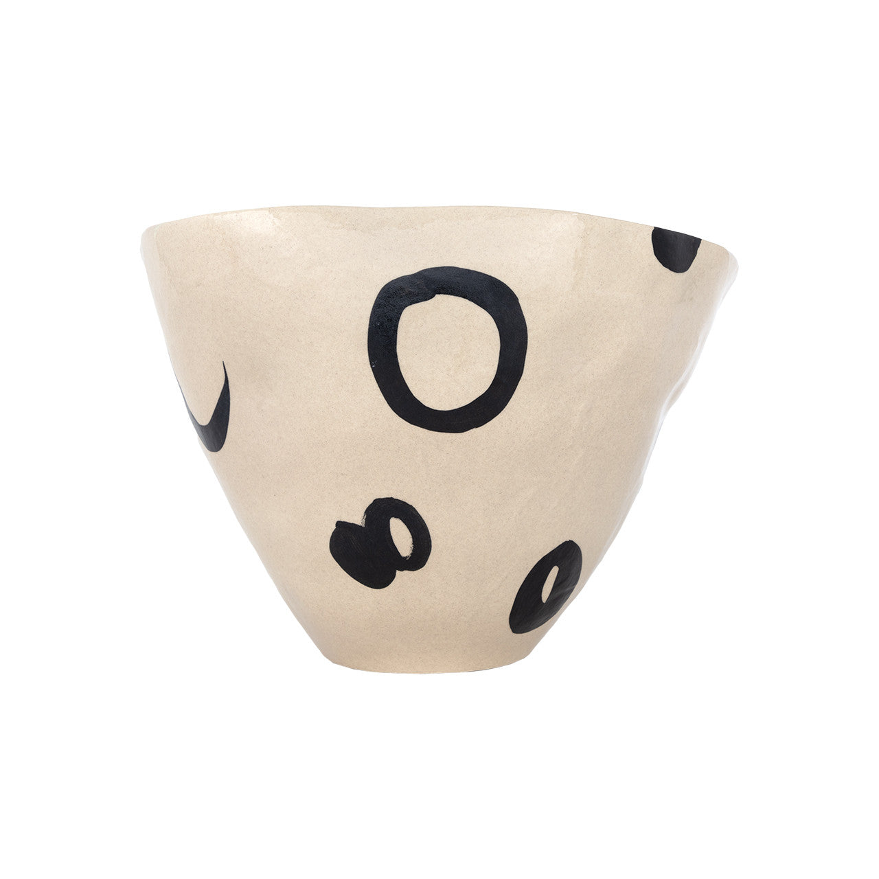 The Clyde Bowl by The Import Collection is a beige, asymmetrical porcelain piece with black irregular circular and oval shapes, creating a striking modern centerpiece against a white background.