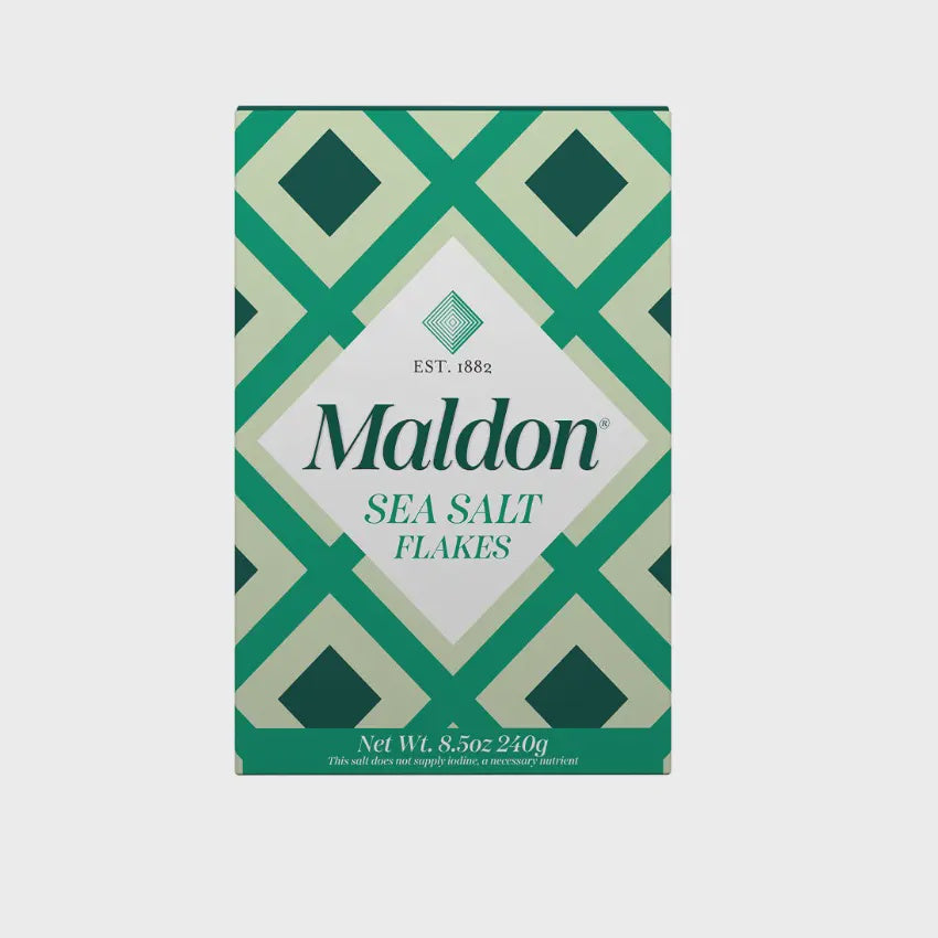 A package of Faire's Flaky Maldon Sea Salt features a green and white geometric design that accentuates its flaky texture. The front prominently showcases "Established 1882" alongside "Net Wt. 8.5oz 240g.