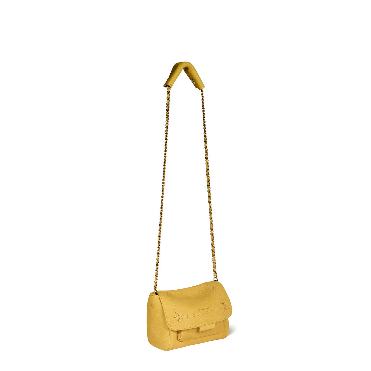 The Lulu Small Bag by Jerome Dreyfuss, a small yellow purse with a gold cross-body chain strap, hangs from a hook. This mini messenger bag features a flap closure and maintains a simple, elegant design.