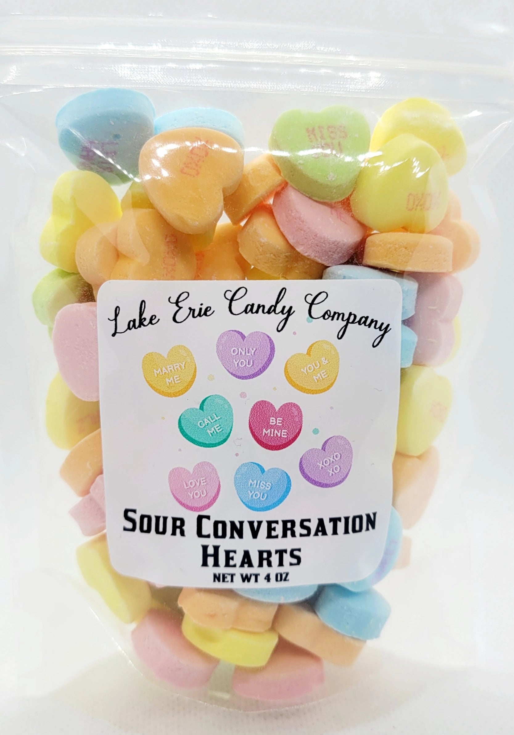 A clear bag of Faire's Lake Erie Valentine Candy—pastel-colored sweets with cute phrases like "Be Mine" and "Love You." Perfect for Valentine's Day. Net weight: 4 oz.