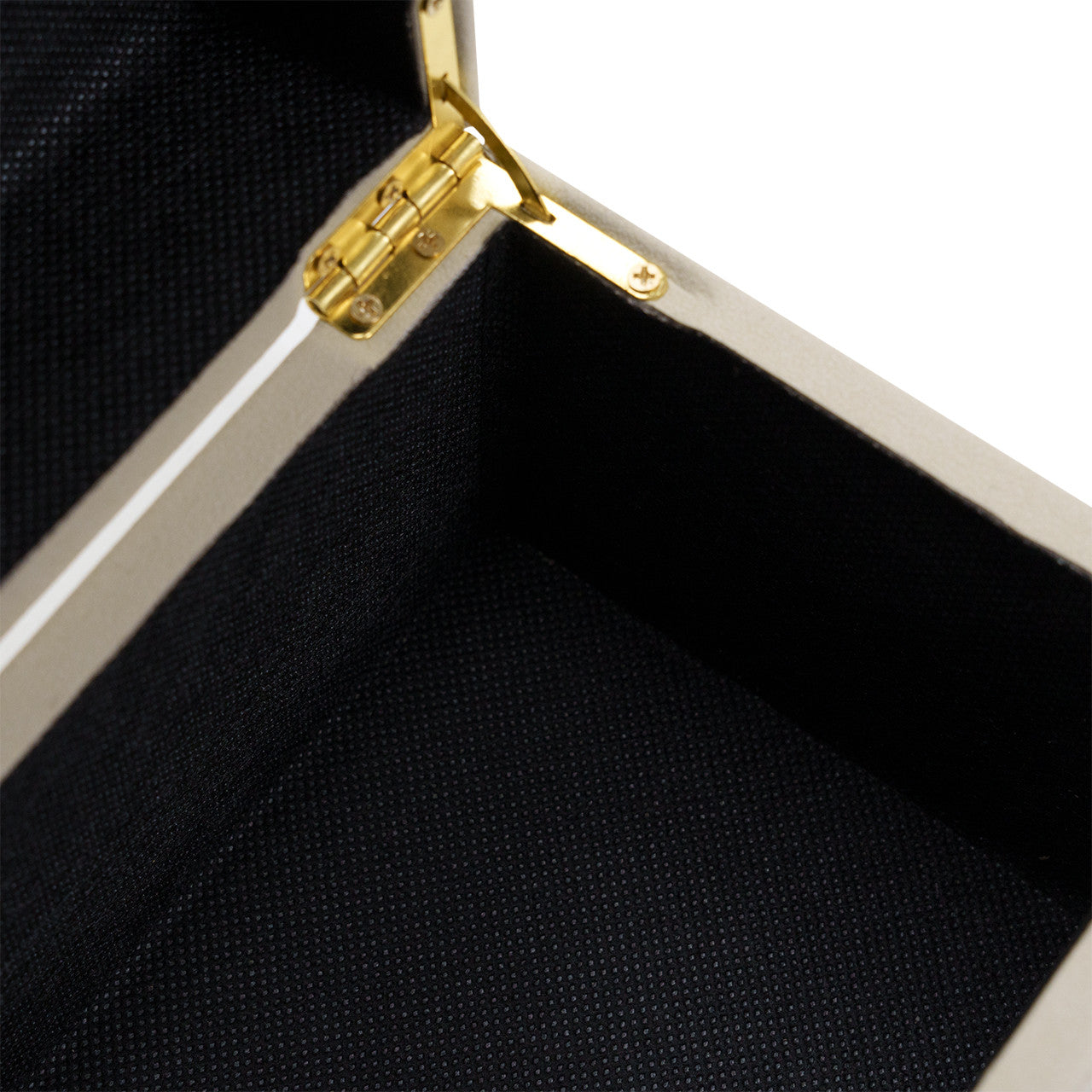 Close-up of the inside corner of the open Ramato Box by The Import Collection, featuring a gold hinge. Its black textured fabric interior contrasts with the light, neutral exterior—ideal for modern home decor.
