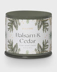 A sophisticated green jar candle from Creative Co-op, the Illume Balsam & Cedar Plant-Based Candle, features elegant illustrations of pine branches with gold accents. Weighing 11.8 oz (335 g), it embodies an aesthetic similar to that of a Vanity Tin Candle.