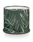 The Vanity Tin Candle by Creative Co-op features a green finish with a delicate pine branch design, exuding the fragrant charm of Balsam & Cedar. Its single wick is set against a plain white background, capturing nature's essence in an elegant form.