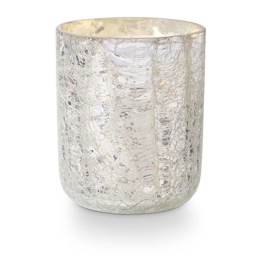 The Creative Co-op Crackle Glass Candle Small features a silver mercury glass votive holder with a crackle finish that gently reflects light. This cylindrical candle holder, with its textured surface, enhances decor and pairs beautifully with a small boxed candle to create an elegant ambiance.