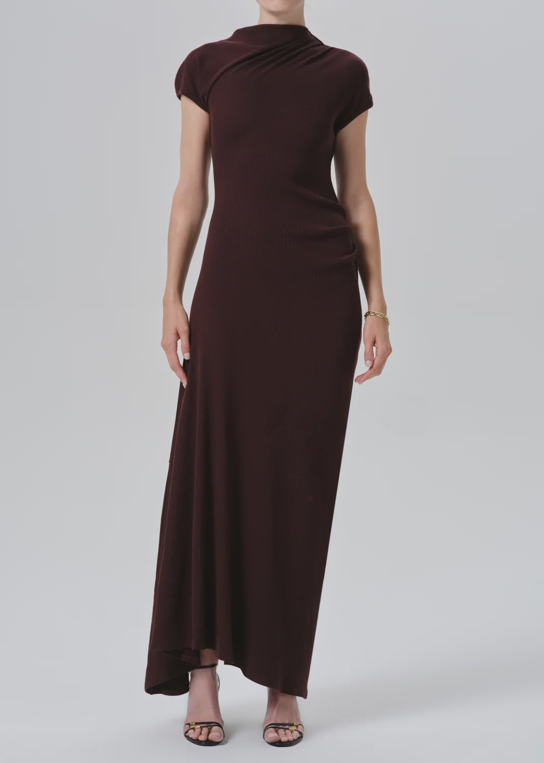 Kira sculptural dress by Citizens Of Humanity/AGOLDE in black, styled with heels against a simple background.