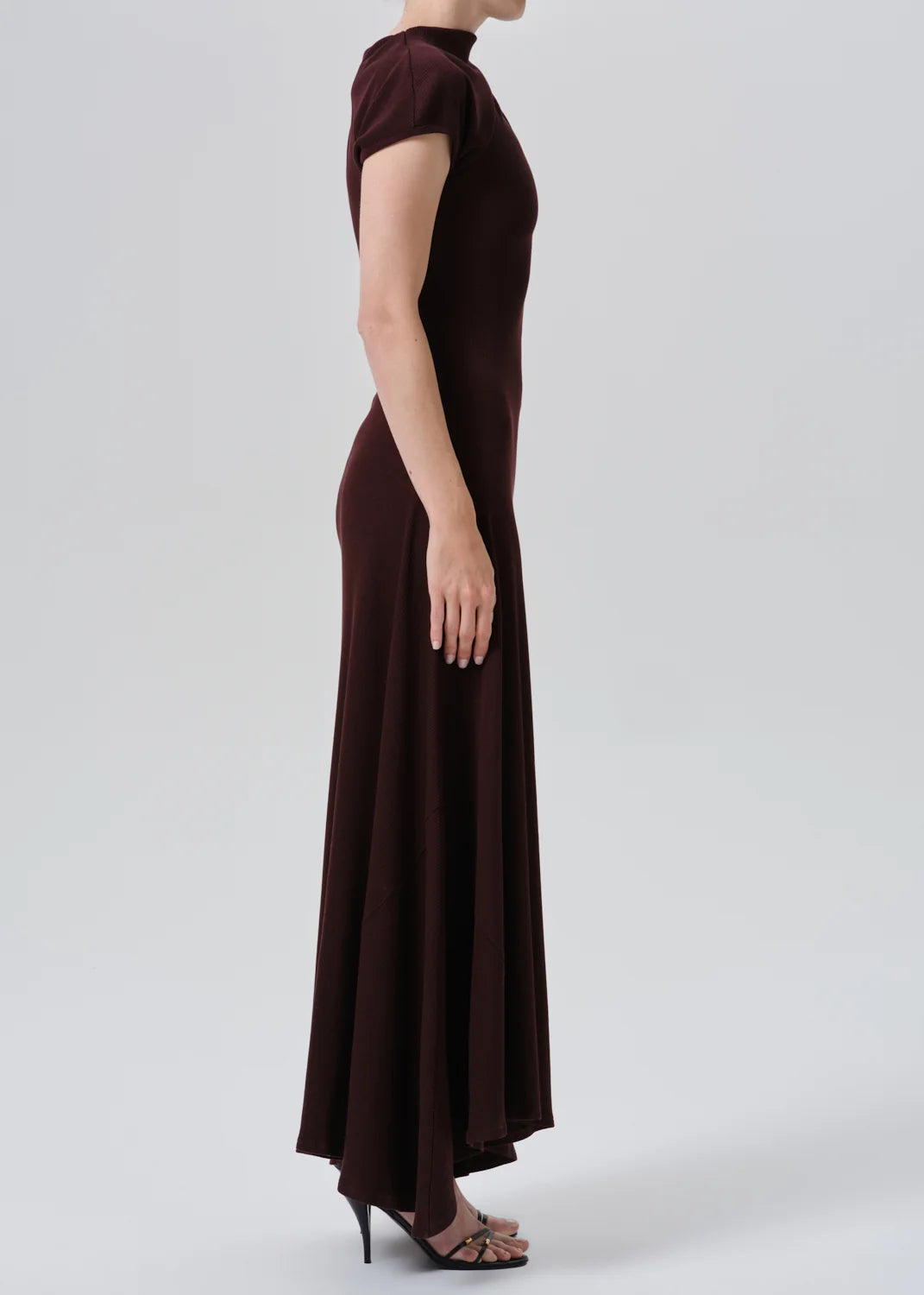Kira sculptural dress by Citizens Of Humanity, side view on model against neutral background.