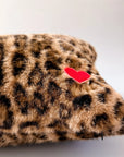 Leopard print lumbar pillow with red heart patch in faux fur by Faire, ideal for accenting sofas or beds.