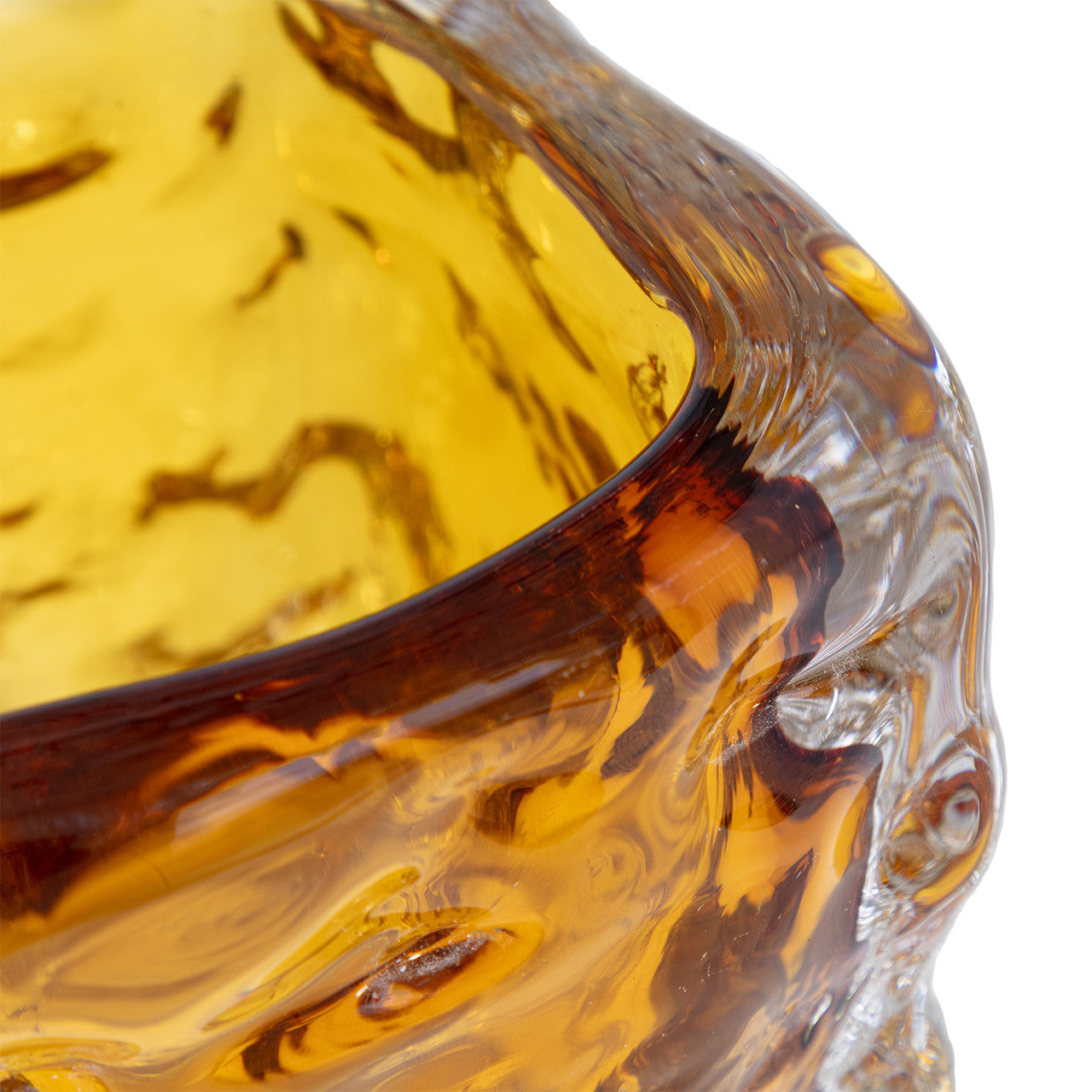 Close-up of the amber 49-704 bryson Vase by The Import Collection, featuring a textured wavy surface. This handcrafted glass vase is translucent, allowing light to emphasize its intricate details against a white background.