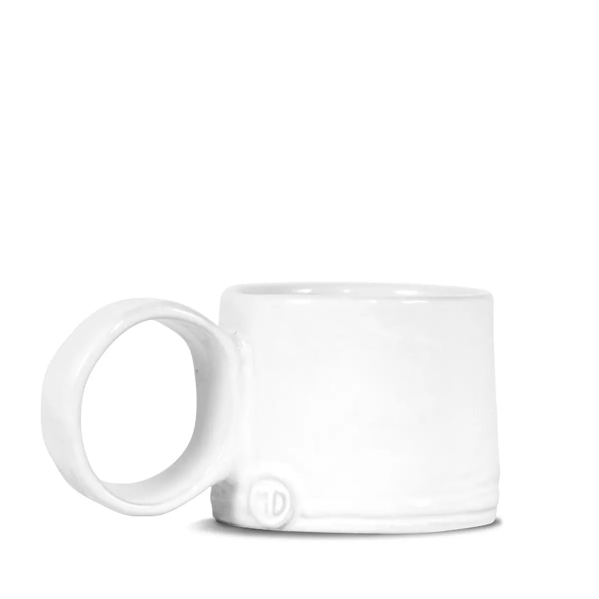 The Montes Doggett Espresso Cup NO. 926 is a minimalist white ceramic cup with a large round handle and handcrafted look, set against a plain white background. This high fired cup is both dishwasher and microwave safe.