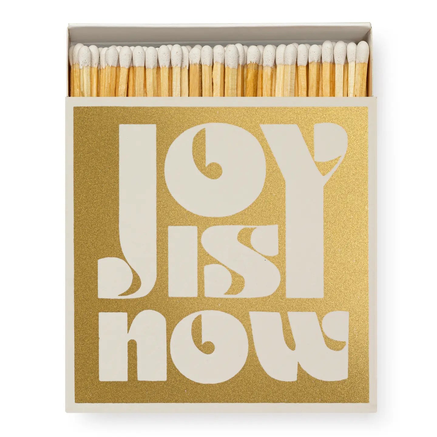 A box of Faire Matches/Square features a gold cover with bold white "JOY IS NOW" text. White match heads are partially visible at the top, reflecting the product’s unique matchbox design.