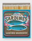 The Square Matches by Faire feature a retro sardine can design with illustrated sardines and text reading "Staying Close," "Sardines," and "We're Better Together." These nostalgic matchboxes add a fun touch to any space.