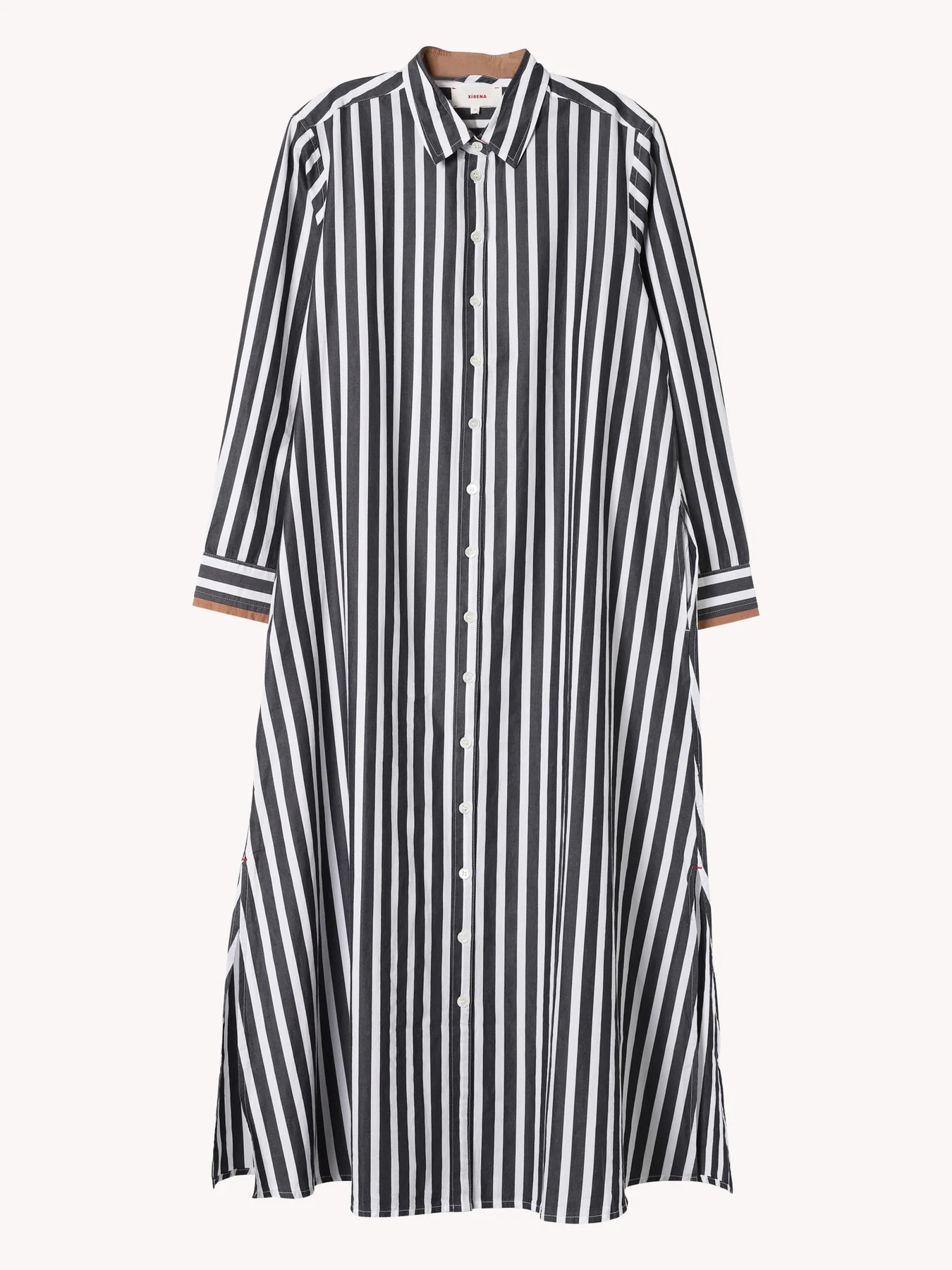 The Xirena Boden Dress is a long-sleeved cotton poplin shirtdress with black and white vertical stripes, a collar, slightly flared hem, and contrasting horizontal striped cuffs.