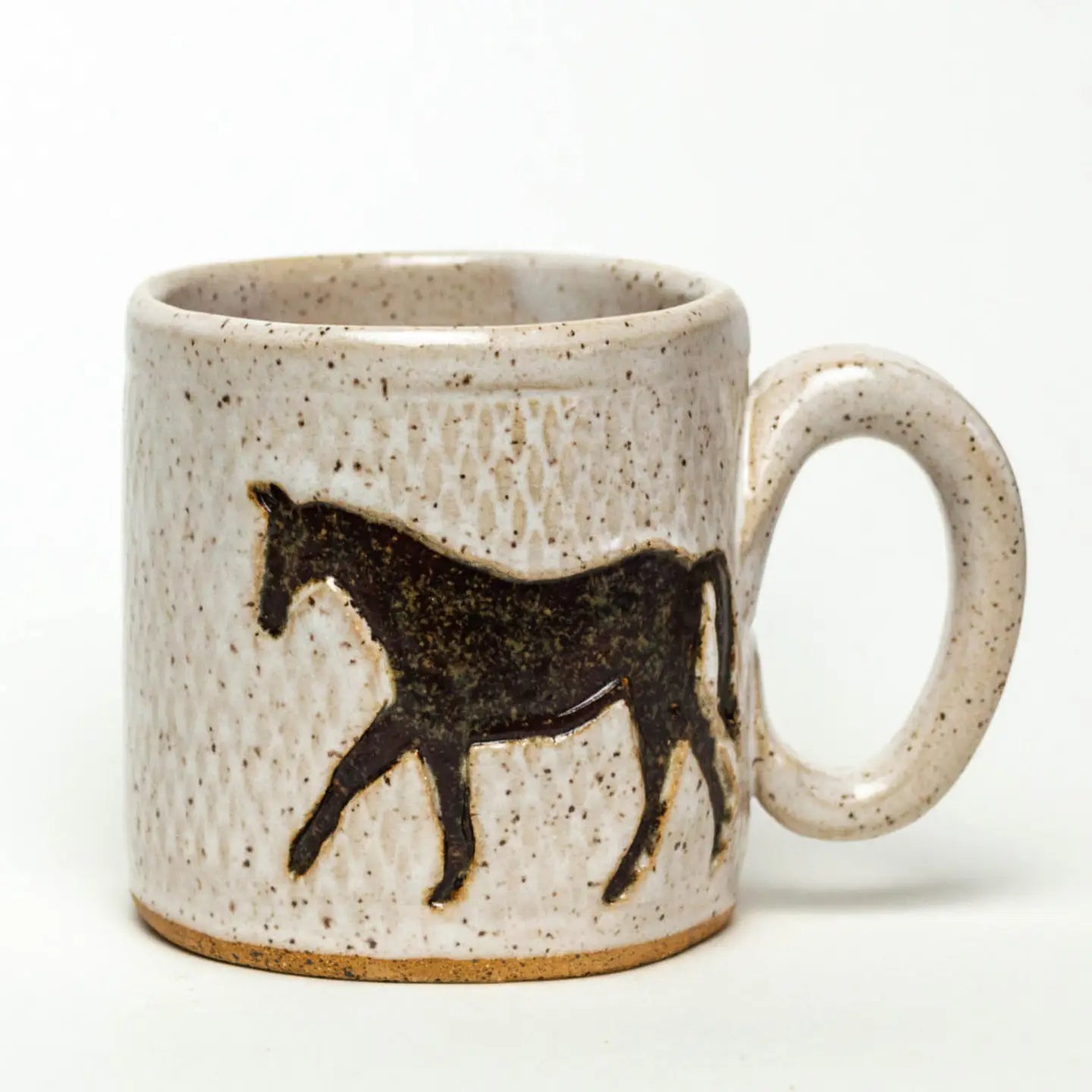 The Faire Ceramic Mug features a black horse silhouette on a speckled beige surface. Its large handle offers practicality and style, is microwave safe, and complements any plain white backdrop.