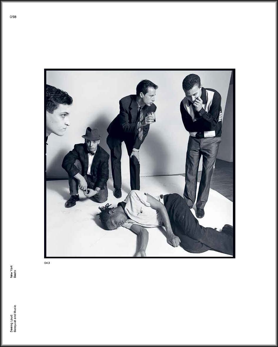 Five men are in a studio; four gaze at a fifth on the floor. This black-and-white image with a wide white border captures Basquiat's raw energy, as featured in "Seeing Loud, Basquiat and Music" by Simon & Schuster Inc.