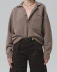 Agatha Rugby sweater by Citizens Of Humanity/AGOLDE in dark knit, paired with black pants and a gold chain necklace.