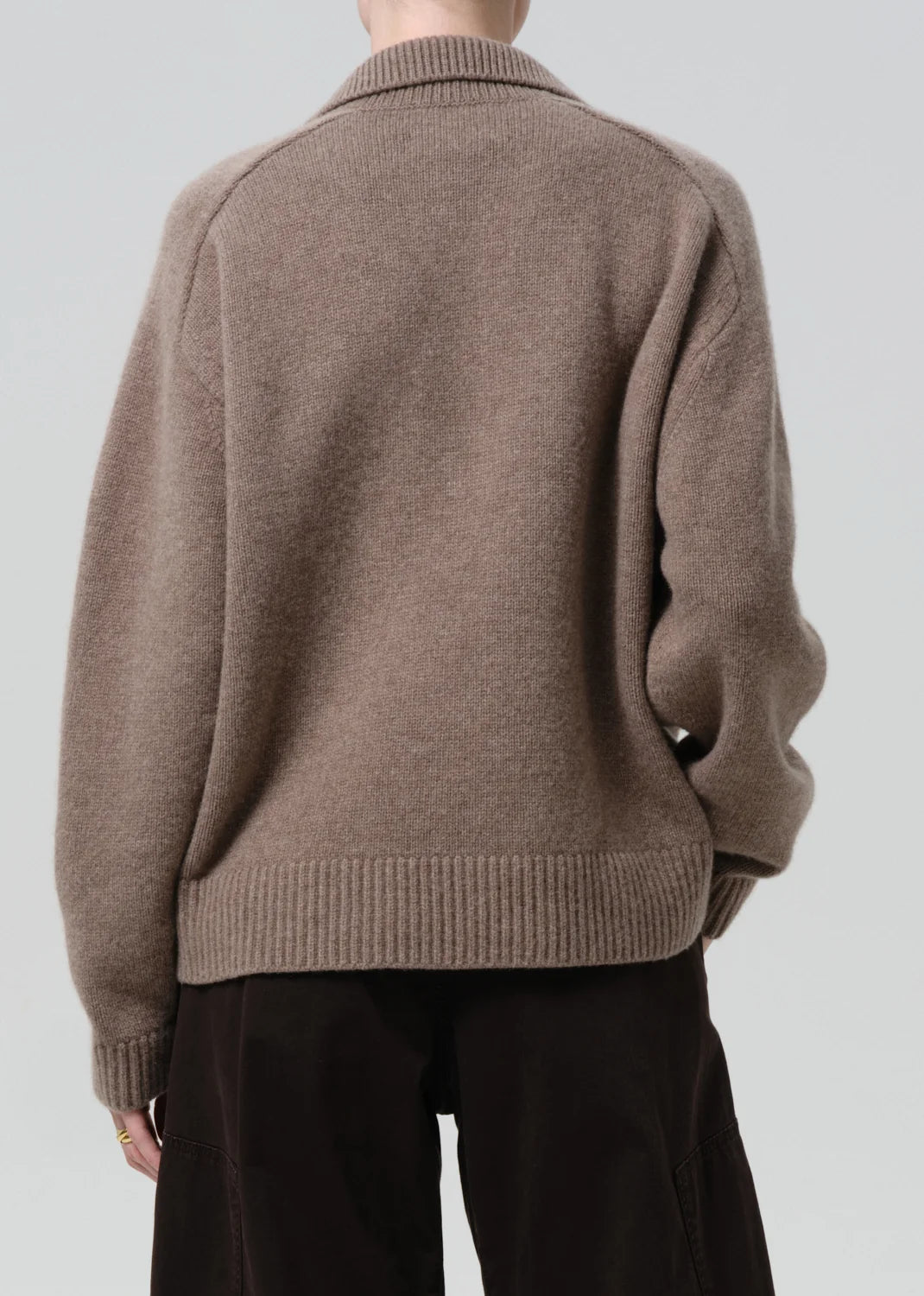 Brown wool-cashmere Agatha Rugby sweater by Citizens Of Humanity/AGOLDE, paired with dark pants, plain backdrop.