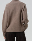 Brown wool-cashmere Agatha Rugby sweater by Citizens Of Humanity/AGOLDE, paired with dark pants, plain backdrop.