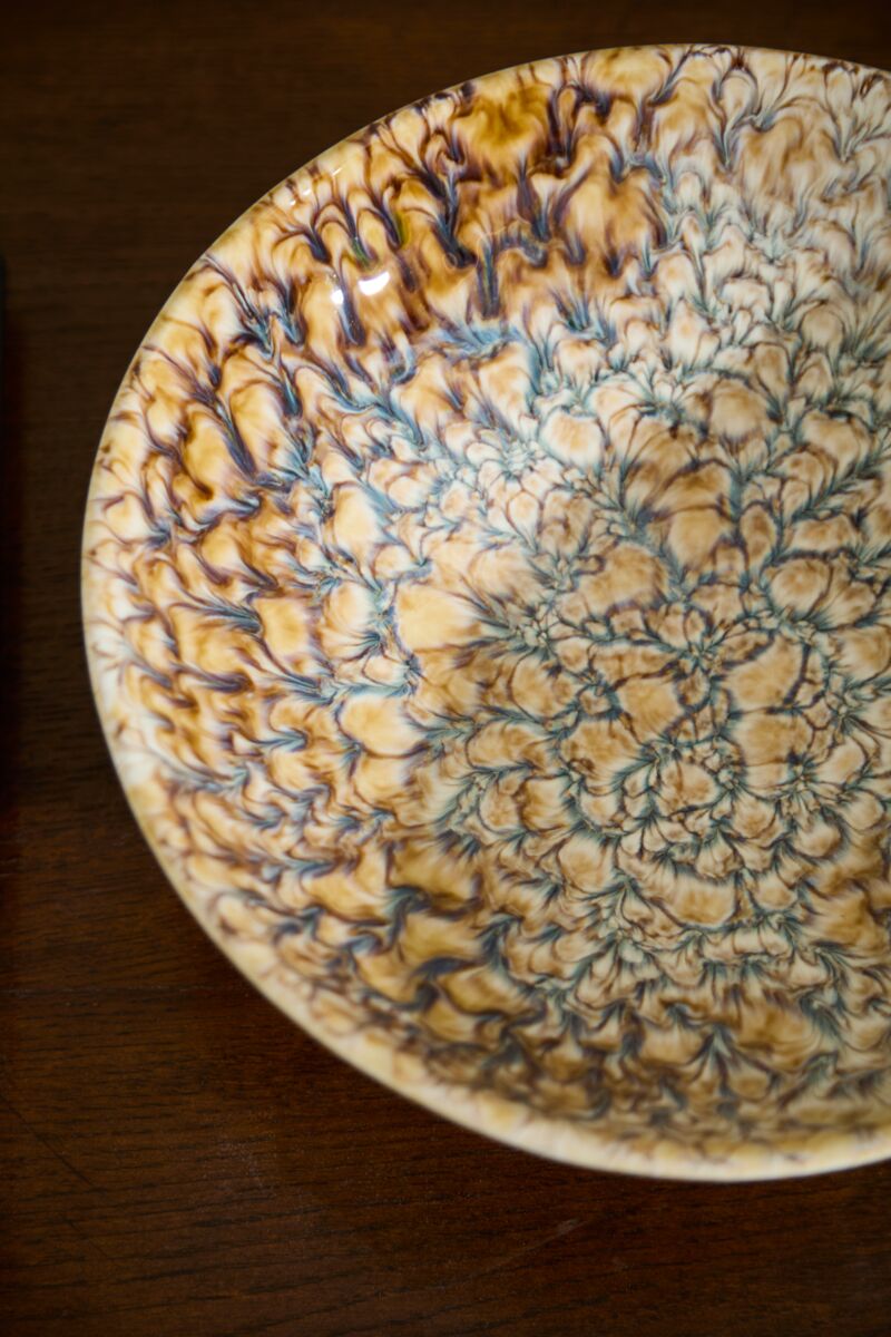 The Walden Bowl by Accent Decor features intricate textured patterns in cream, brown, and blue, adding sculptural flair to any space when displayed on a wooden surface.