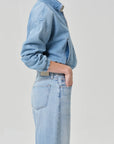 Wearing the bubble bomber in marseille by Citizens Of Humanity/AGOLDE and matching high-waisted jeans, a person stands in profile against a plain background, hand in pocket and face partially out of frame.