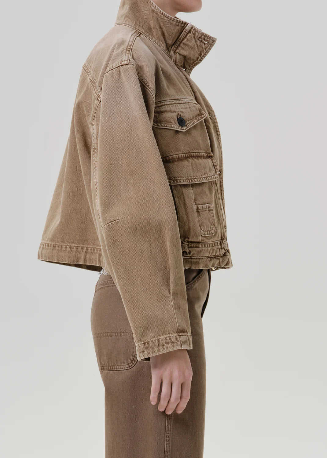 Tan funnel collar barn jacket by Citizens Of Humanity/AGOLDE shown in profile against a light background.