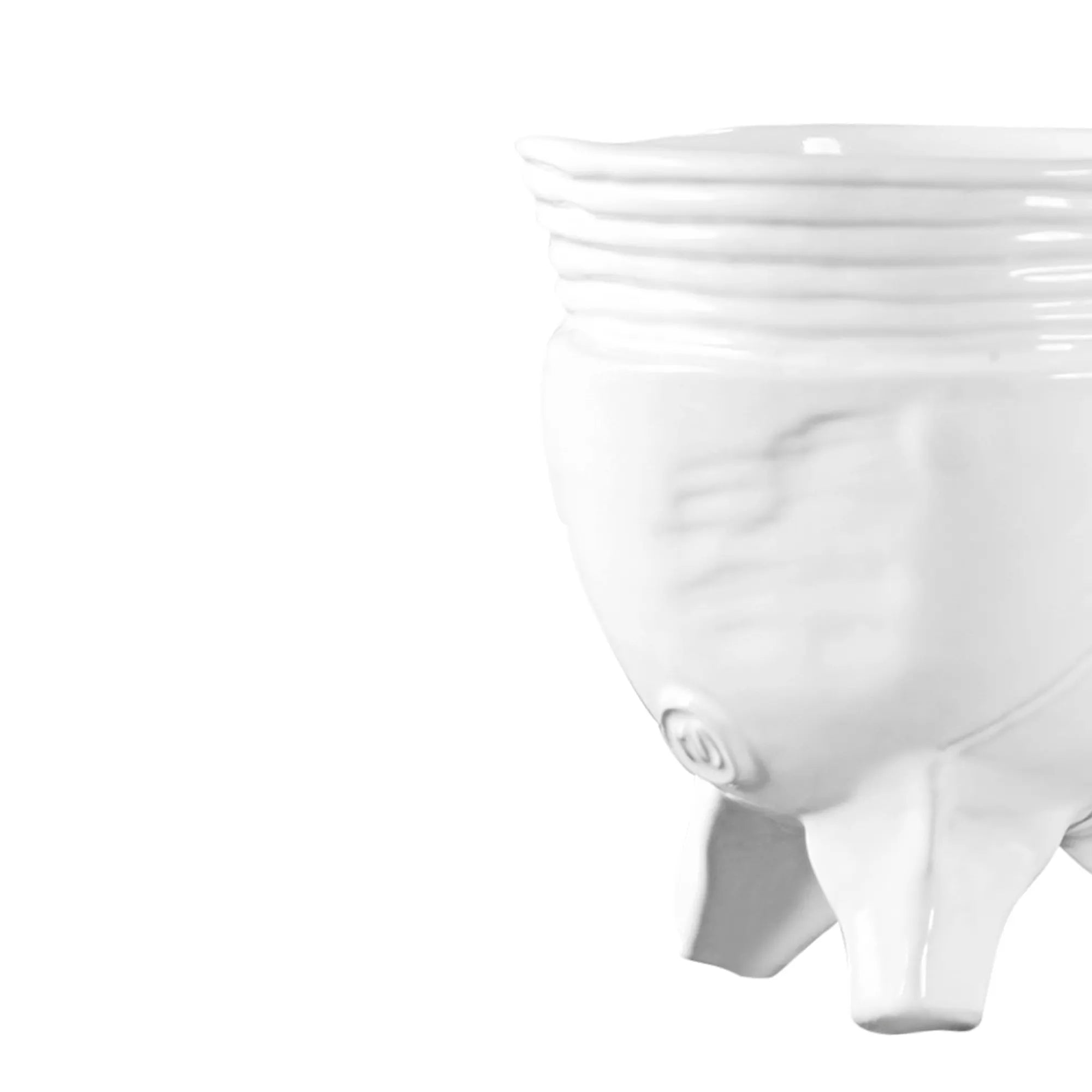 A close-up of the Montes Doggett Footed Bowl No 273, a white ceramic, microwave-safe bowl with three short legs and horizontal ridges near the rim, partially visible on the right against a plain white background.