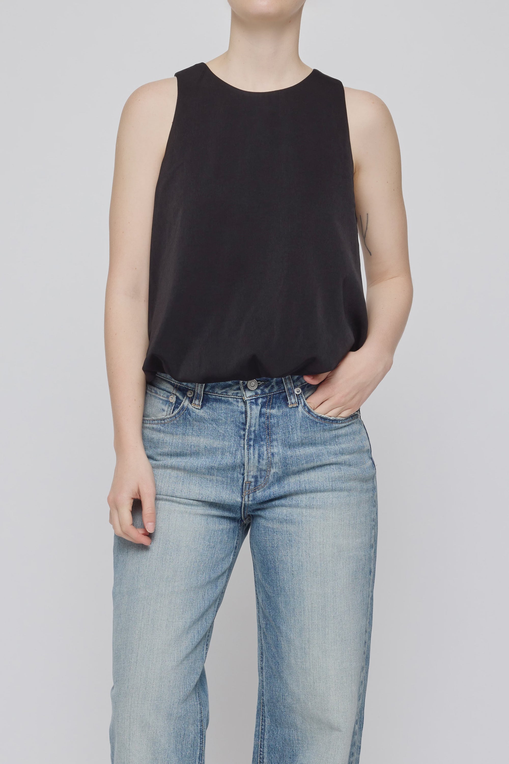 MV Sculpted Satin Top by Moussy in white with light blue jeans, styled simply against a plain background.