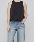 MV Sculpted Satin Top by Moussy in white with light blue jeans, styled simply against a plain background.