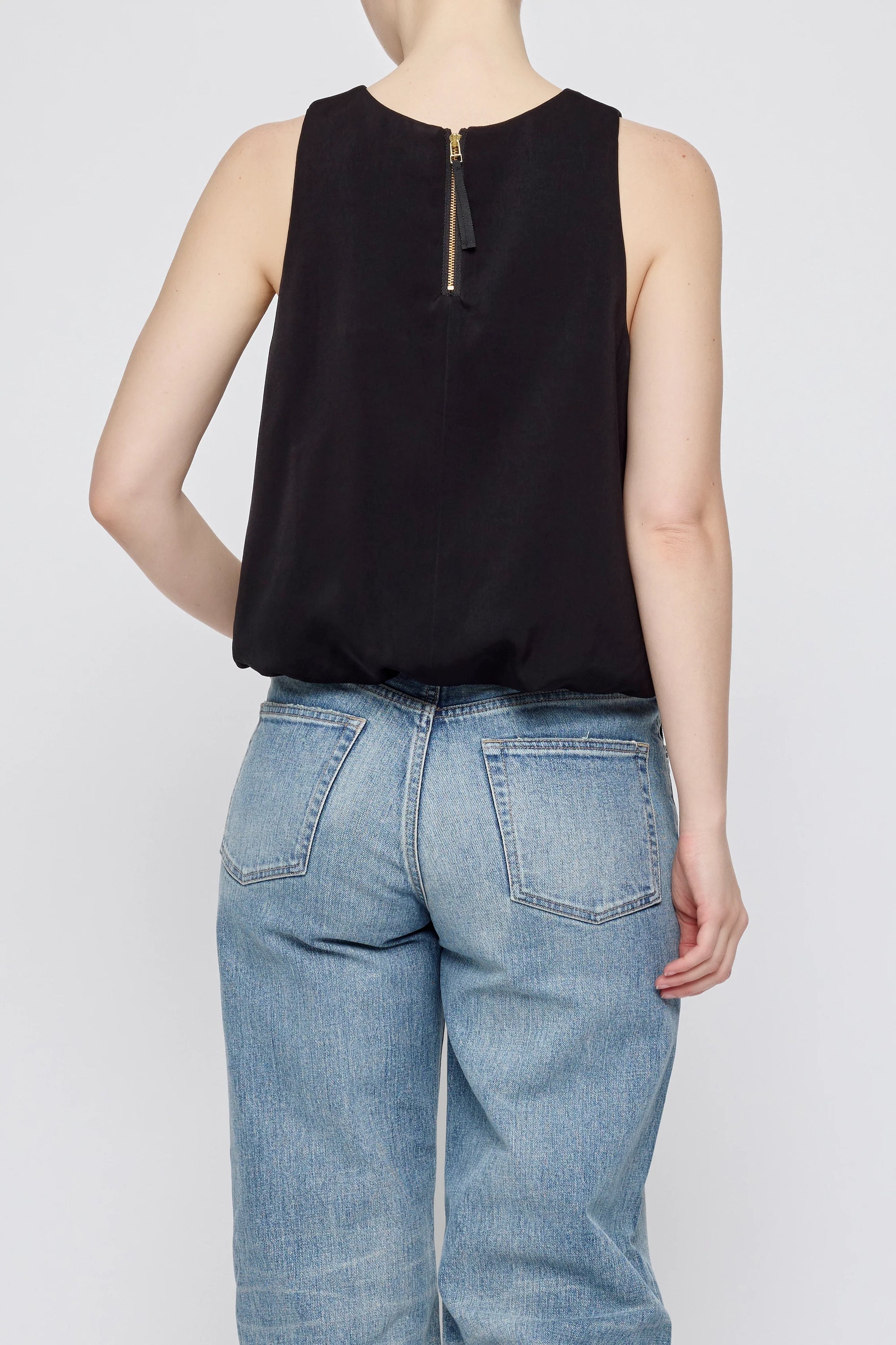 Sculpted Satin sleeveless top by Moussy with back zipper, shown with light blue jeans, rear view.