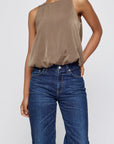 Moussy taupe satin sculpted top styled with blue jeans, shown against a simple light background.
