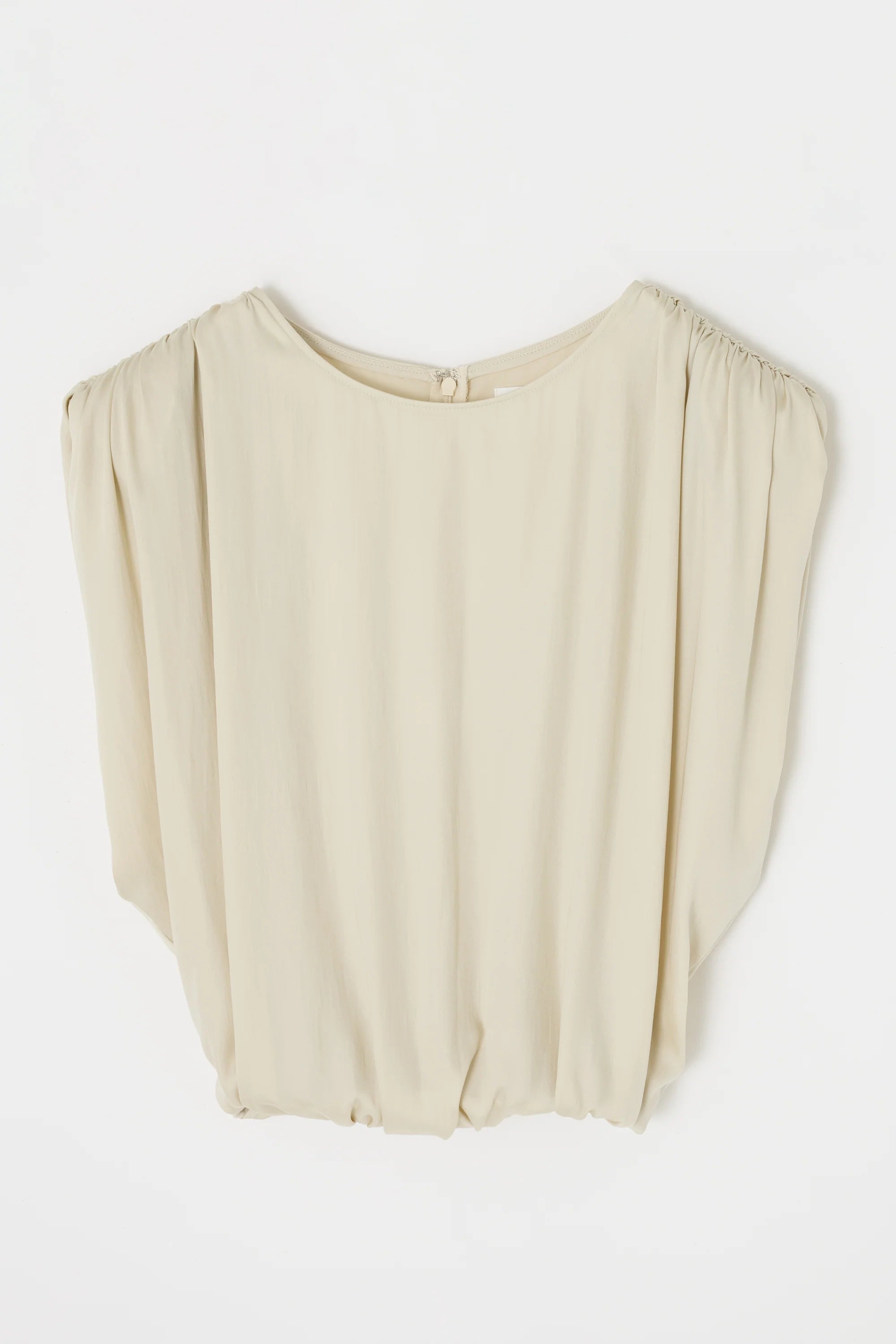 The MV Satin Shell Cap Top by Moussy is a cream, loose-fitting sleeveless blouse with a round neckline, subtle shoulder gathering, back button closure, and relaxed drape for effortless elegance.