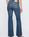 A person wearing a black top and black heels is standing with their back to the camera, showcasing the Moussy Lismore 70's Flare jeans against a plain light background.