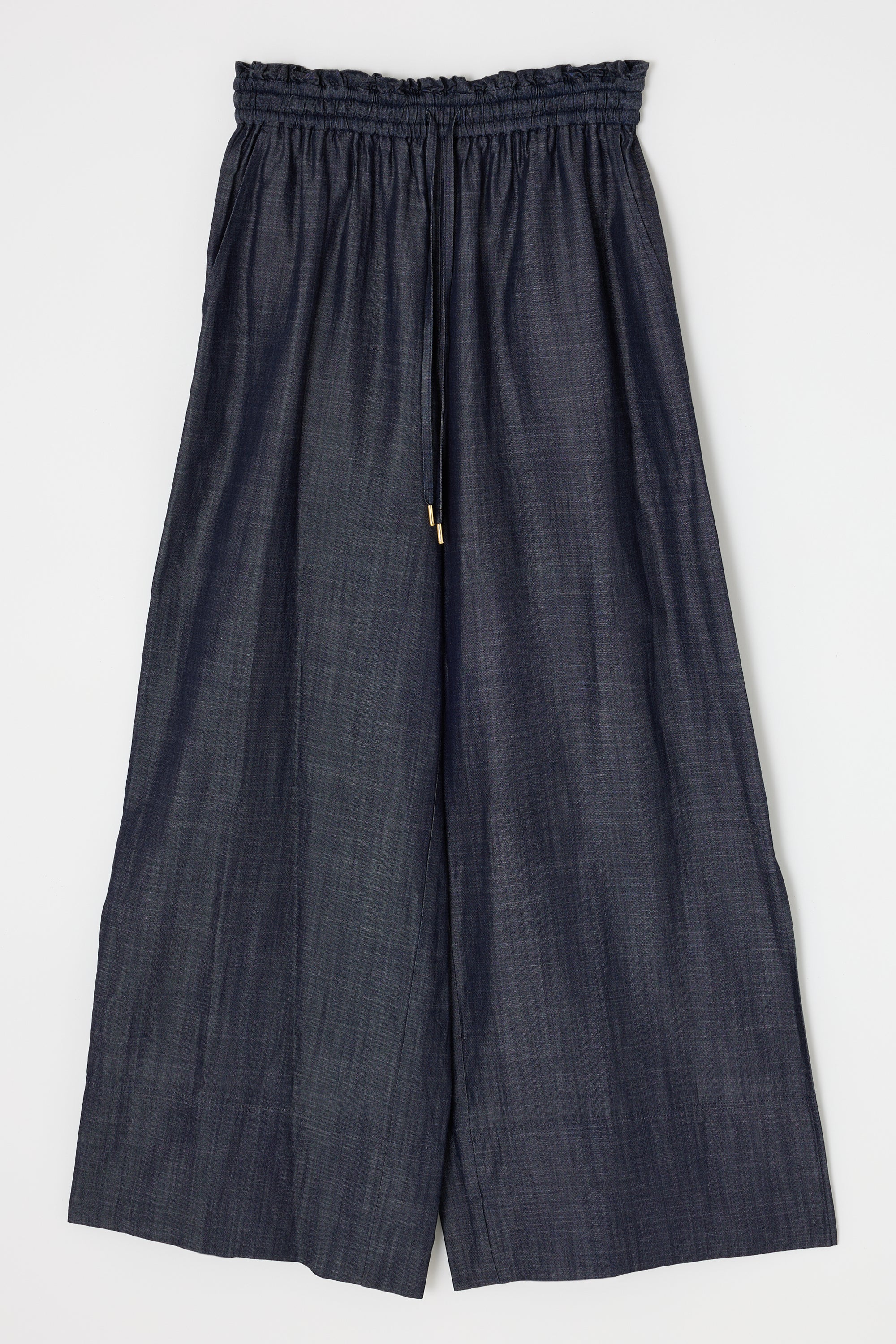 The Moussy High Waist Denim features a wide-leg silhouette in dark fabric with a high rise, adjustable drawstring, and ruffled elastic waistband. Pants are shown laid flat on a white background.