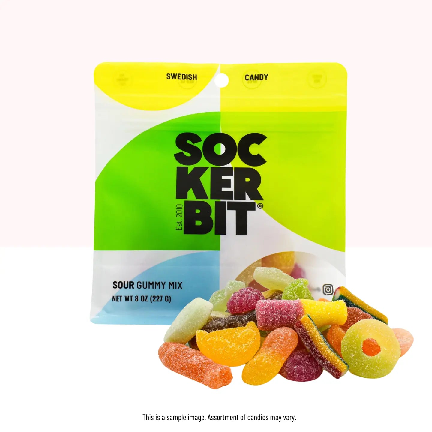 A vibrant green and white package labeled "Sockerbit Swedish Candy" from Faire offers a sour gummy mix made with non-GMO ingredients. Inside, discover gummies in diverse shapes and colors such as orange slices, green rings, and red tubes.