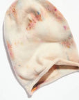 The Faire Cashmere Beanie is a soft, hand-dyed cream hat with subtle pastel tie-dye patterns, shown flat on a white background. Made in the USA.