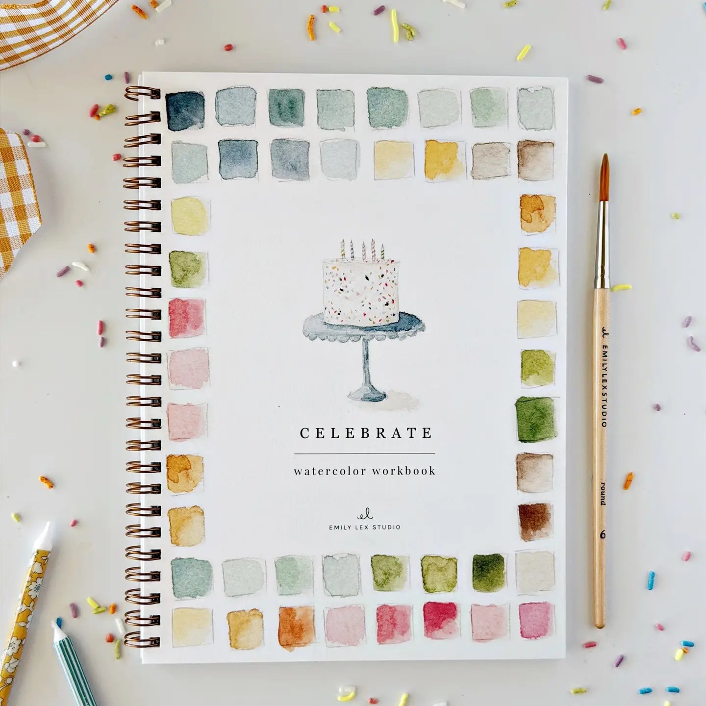 Spiral-bound Celebrate watercolor workbook with cake cover and colorful art accents by Faire.