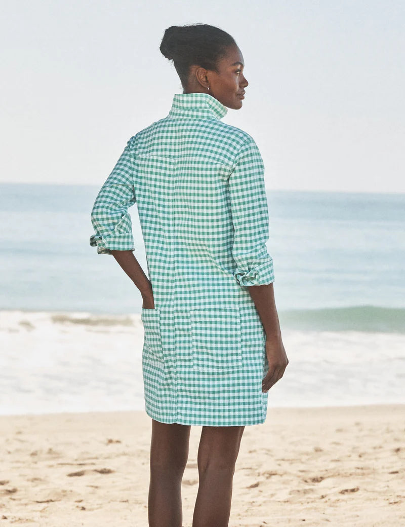 A woman stands on a sandy Southern Ireland beach, facing the ocean in the Frank & Eileen Southern Dress. Her hair is tied back as gentle waves roll in behind her.