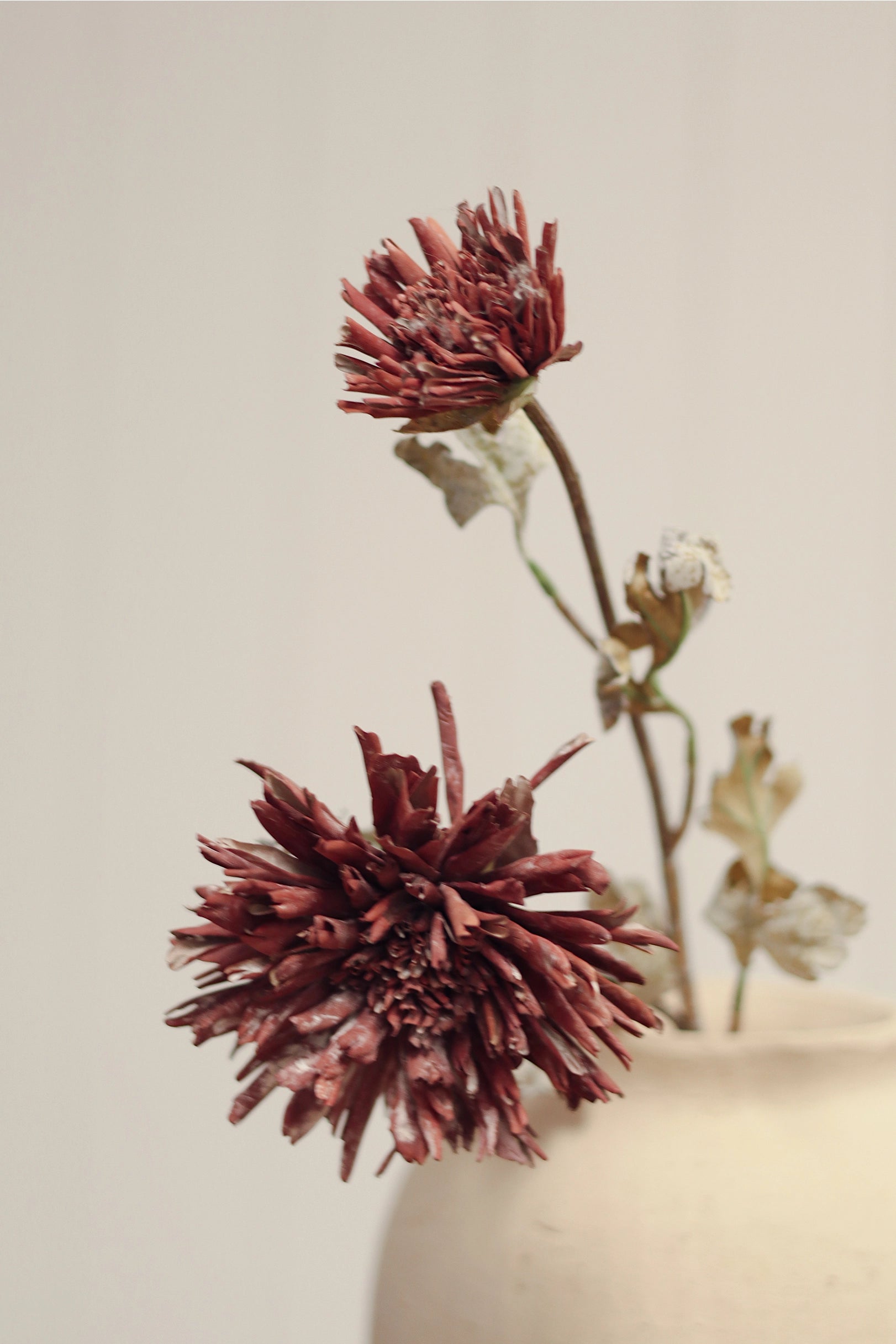 Burgundy Dahlia Spray faux flowers in a decorative vase by Faire, shown against a plain background.