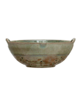 The Creative Co-op Berry Bowl is a rustic, round stoneware piece featuring earthy green and aqua tones. It includes two small handles on either side for easy gripping and numerous drainage holes on the bottom half. The reactive glaze lends it a handmade appearance, showcasing an artisanal design.