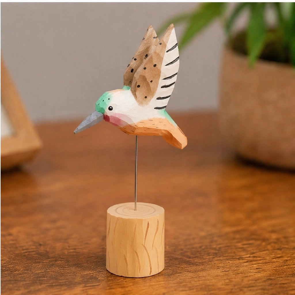Hand-painted brown carved hummingbird on wire stand by Faire, displayed on a polished wood surface.