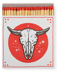 An open box of Faire's Square Matches features a striking range and has red lid designs with a bull skull alongside the words "RUN FREE BE WILD.