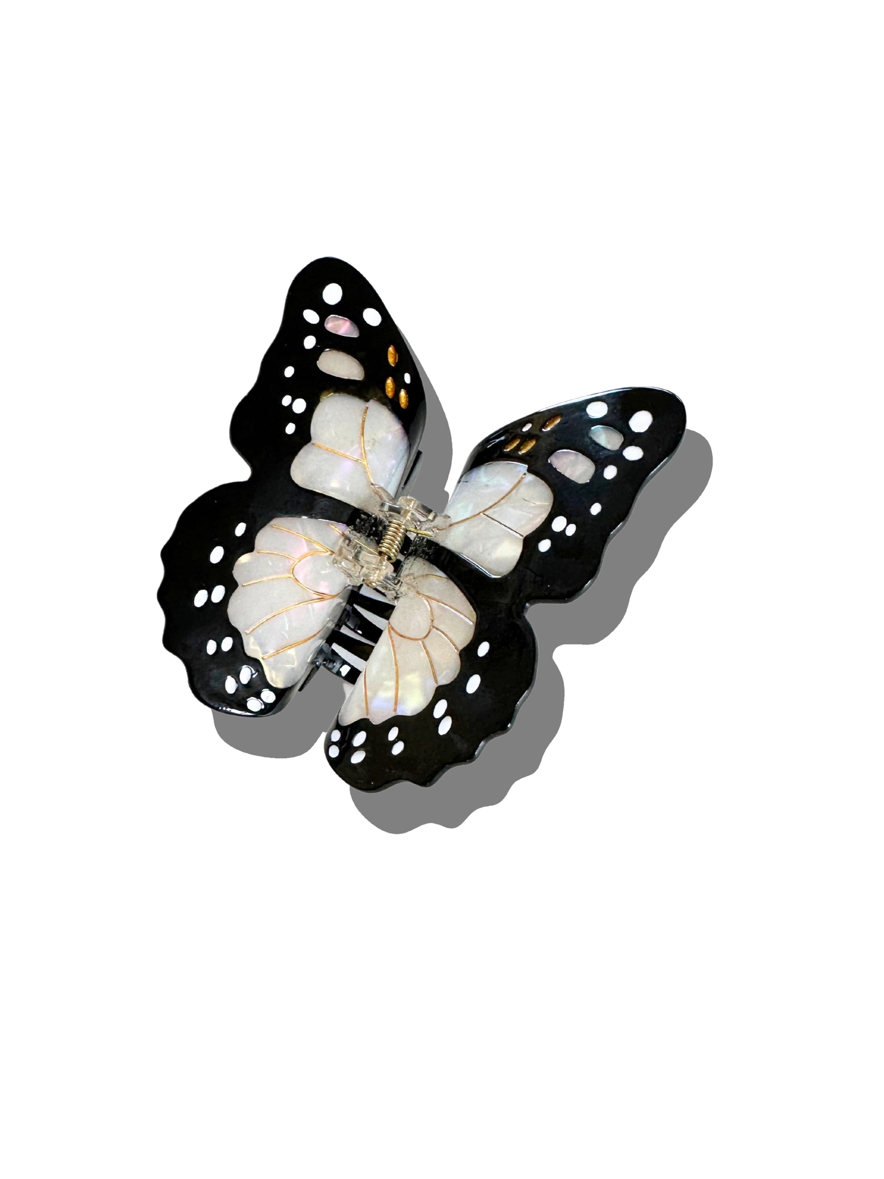 The Faire Fashion Hair Clip is a black and white butterfly design with white spots, made from eco-friendly cellulose acetate and shown on a white background with shadow.