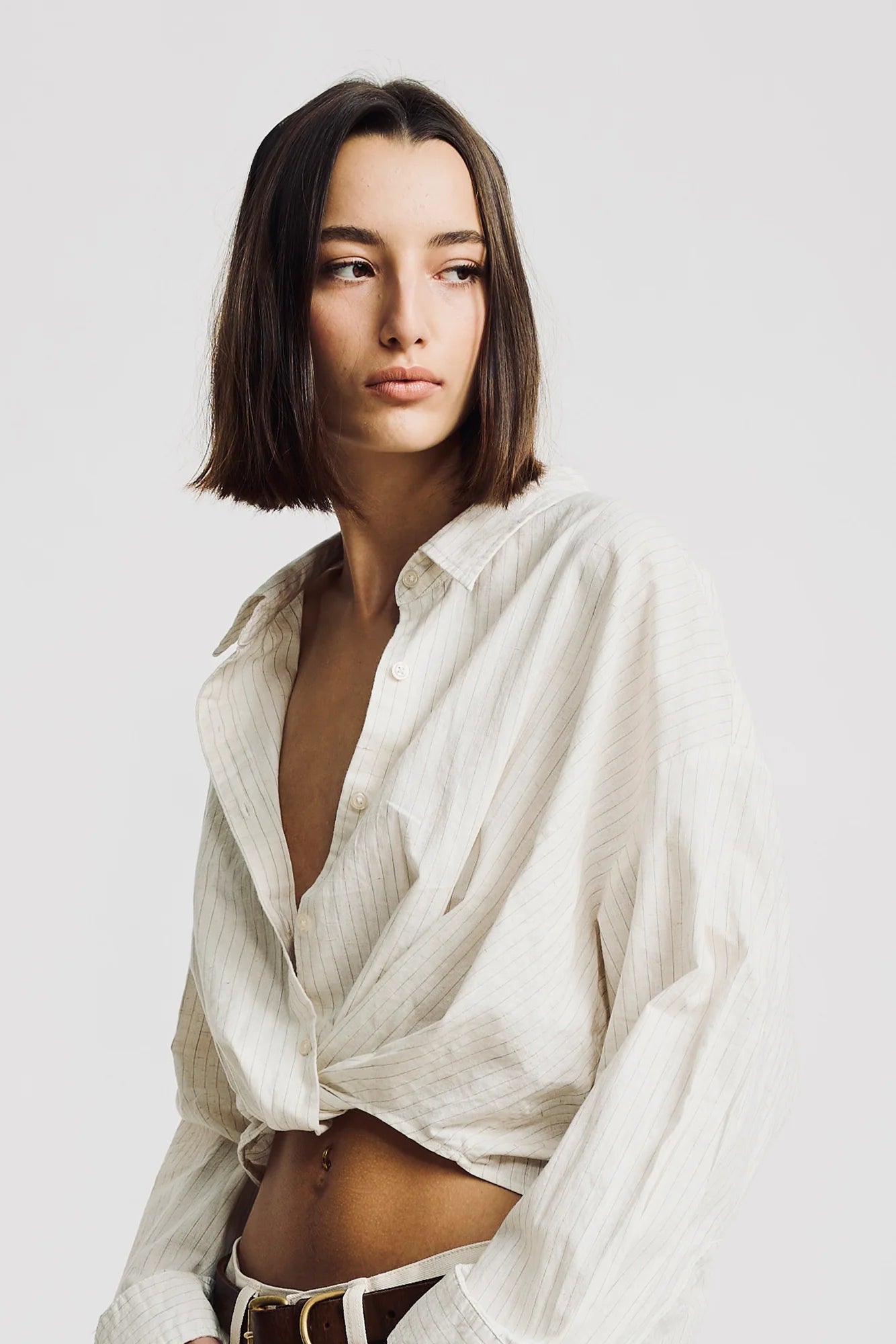 Denimist striped white TWISTED FRONT SHIRT, relaxed fit, modeled by woman with shoulder-length brown hair.
