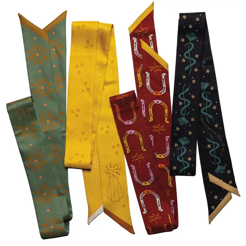 Five vibrant Faire Twilly Scarves are displayed side by side, featuring bold geometric and illustrated patterns—including a striking horseshoe design—in green, yellow, red, and black. Perfect as a unique gift silk scarf.