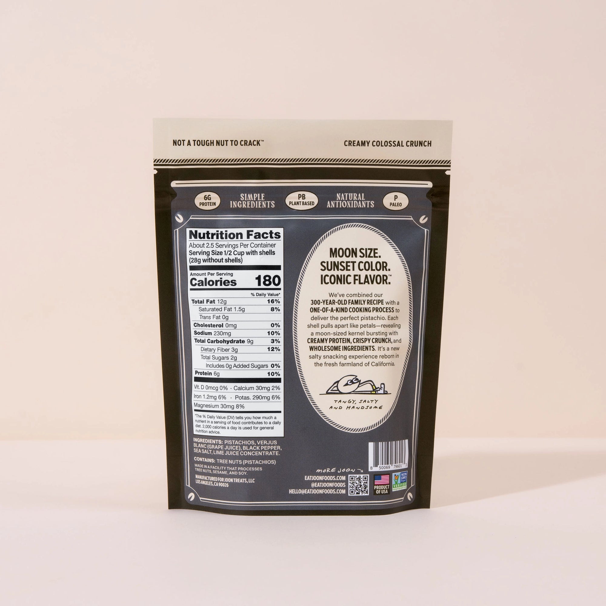 An upright package of Joon Pistachios by Faire displays the back label with nutrition facts and product details. The brown packaging with cream and white accents emphasizes these pistachios as a healthy snack choice.