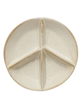 The Creative Co-op Stoneware Peace Sign Dish is a round, cream-colored plate with raised dividers forming three triangular sections. Its speckled, reactive glaze adds a rustic touch.