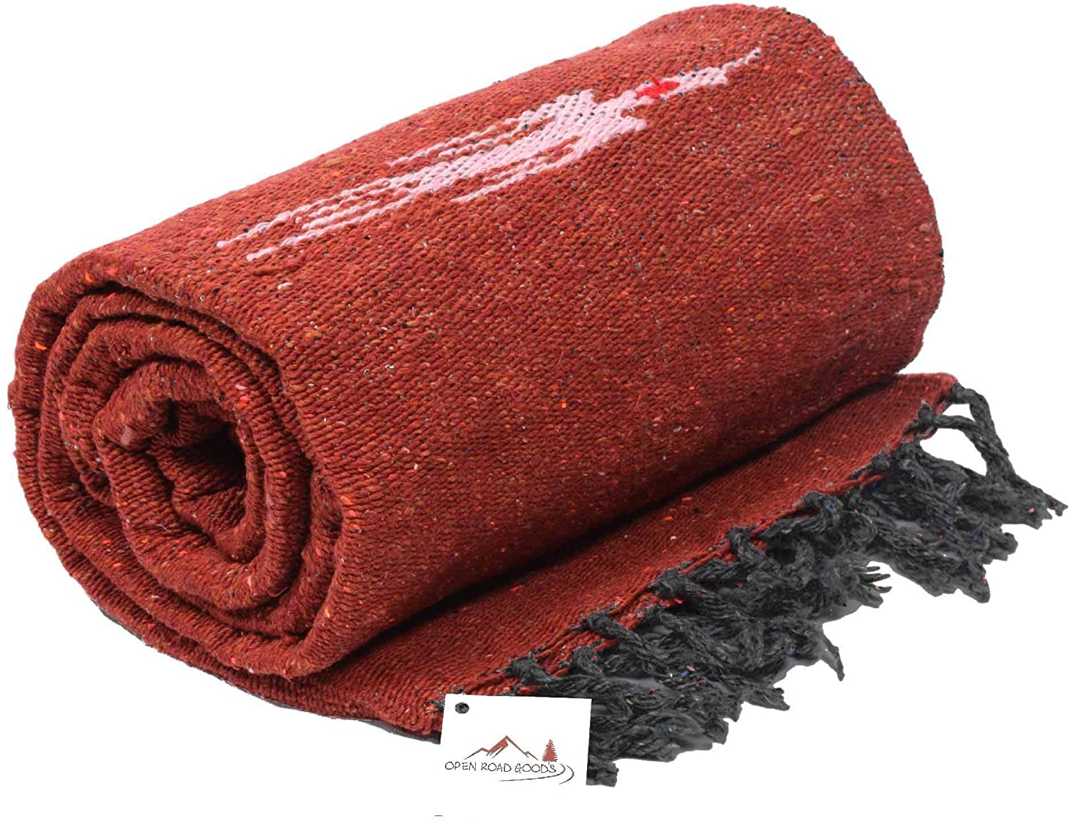 A rolled-up Rust Red Baja Thunderbird Mexican Blanket by Faire, featuring white and red patterns, black fringed edges, and a small tag with a mountain logo and "Open Road Goods." Handmade in Mexico.