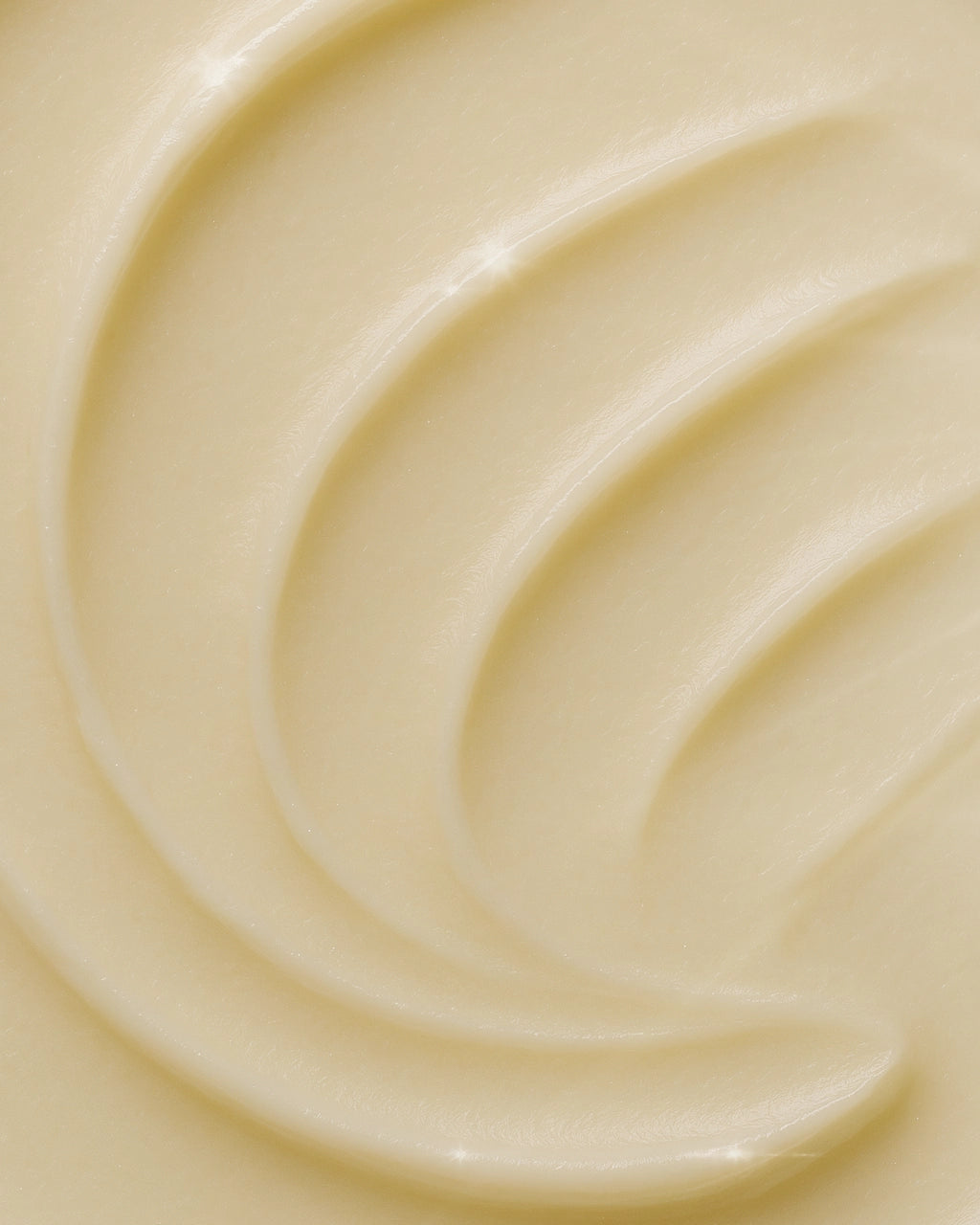 Close-up of Faire's Magnesium Lavender Tallow Cream 4oz reveals a creamy, smooth balm with light beige tones and subtle, glossy swirls on its soft surface.