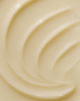 Close-up of Faire's Magnesium Lavender Tallow Cream 4oz reveals a creamy, smooth balm with light beige tones and subtle, glossy swirls on its soft surface.