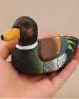 Faire Hand-Painted Carved Basswood Duck in brown held in hand, rustic decor accent from Bungalow Furniture & Accessories.